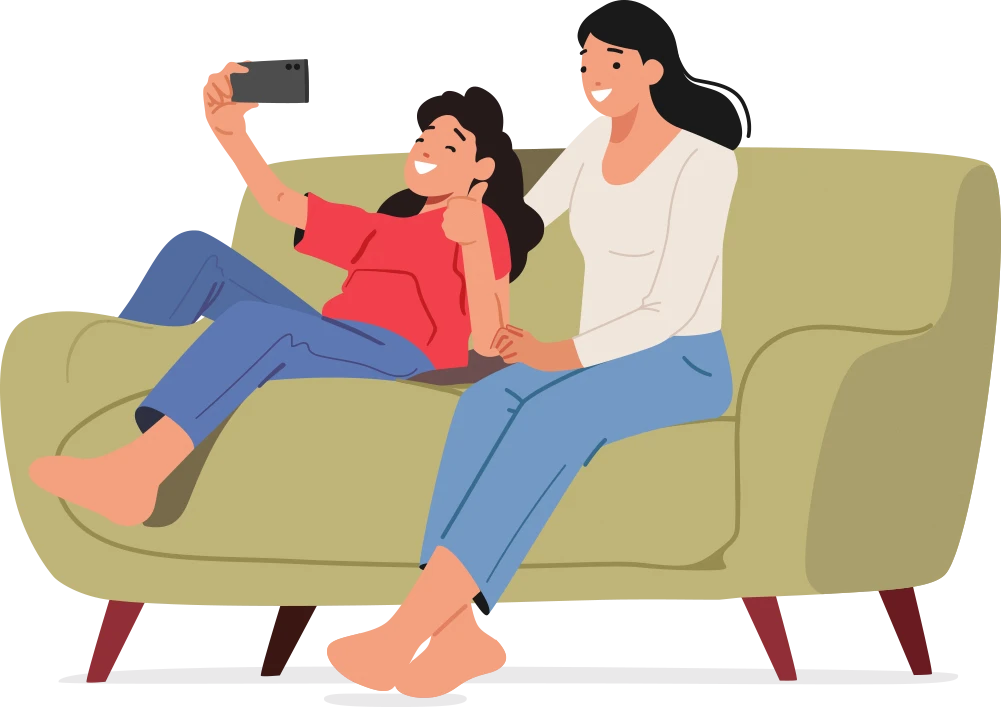 A girl and a woman sitting down on a sofa and taking selfie together